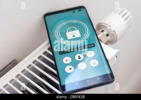 Smart Home: Man Controlling Heating Using App Stock Photo
