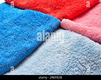 a close up of three different colored towels on a white surface. . Stock Photo