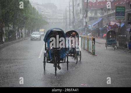 Rickshaw puller carrying passenger when heavy rainfall maid in dhaka, Bangladesh on 22march 2023.Nazmul islam/ alamy live news Stock Photo