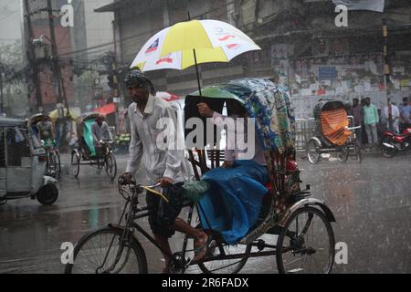 Rickshaw puller carrying passenger when heavy rainfall maid in dhaka, Bangladesh on 22march 2023.Nazmul islam/ alamy live news Stock Photo