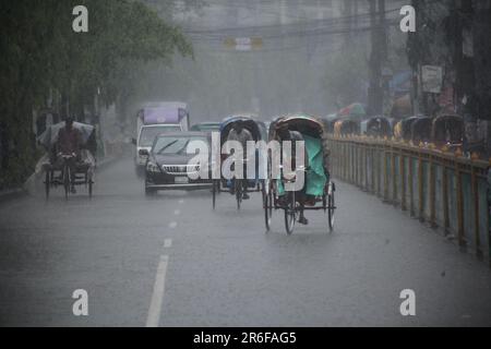 Rickshaw puller carrying passenger when heavy rainfall maid in dhaka, Bangladesh on 22march 2023.Nazmul islam/ alamy live news Stock Photo