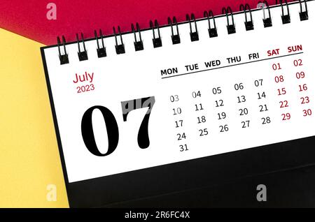 July 2023 Monthly desk calendar for 2023 year on yellow and red background. Stock Photo