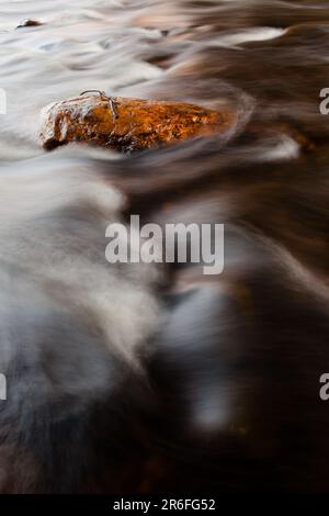 A stream of water cascading through the rocky shore Stock Photo