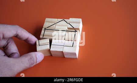 Hand arrange wooden cube with house icon. Copy space for text. Settle down, start a family concept Stock Photo