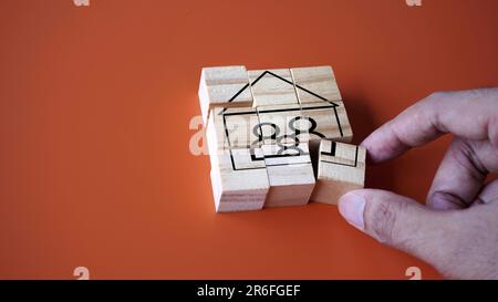 Hand arrange wooden cube with house and family icon. Copy space for text. Settle down, start a family concept Stock Photo