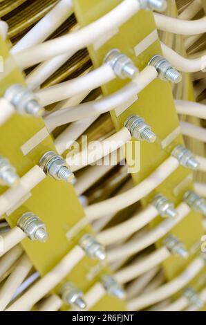 Electrical installation, white insulated wires on green composite panel, vertical close-up shot with selective focus, industrial abstract background Stock Photo
