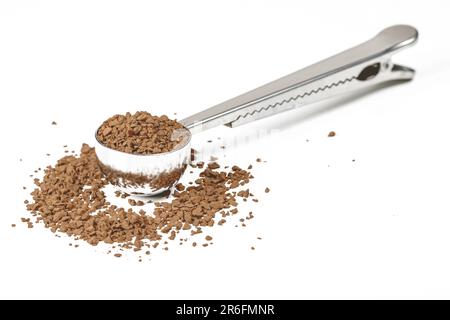 A stainless steel spoon with a pile of brown sugar in its holder, isolated on a white background Stock Photo