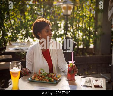 beautiful African-American girl dining in a cafe Stock Photo