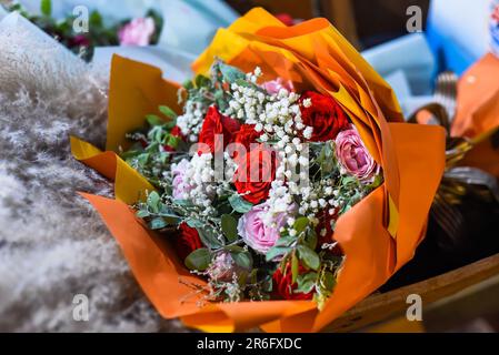 Flower shop made bouquet of roses, gypsophila and Chinese silver grass at night Stock Photo