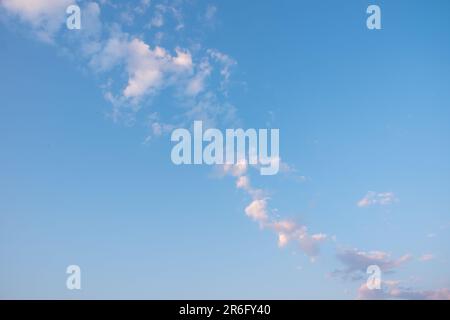 sunset sky with pink clouds, diagonally stripe, grey above. Whispy pink clouds and blue sky diving frame diagonally. Cirrus and cirrocumulus clouds fo Stock Photo