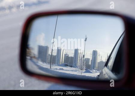 Reflection of the cityscape in the rear-view mirror of the car on a frosty winter day Stock Photo
