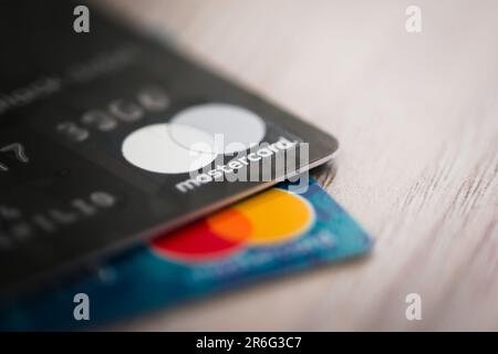 Mastercard logo printed in silver on a black debit card. Close up, brand editorial macro shot. Stock Photo