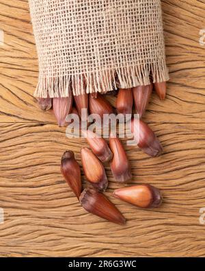 Pinions or pine tree seeds on a bag over wooden table. Stock Photo