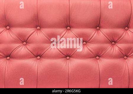 Light red peach colour leather upholstery sofa with pattern button design furniture style decor texture background. Stock Photo