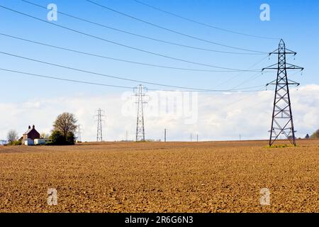 Electricity pylons march across the open, fertile farmland of Angus, Scotland, UK, part of the National Grid power distibution network. Stock Photo