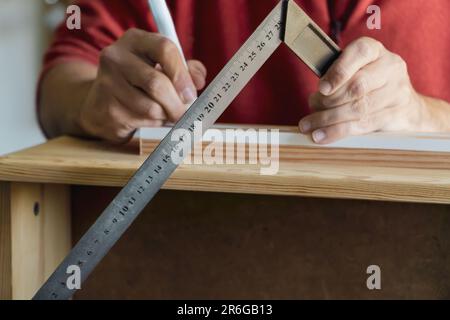 closeup of a carpenter's hand measuring with a traditional ruler. Unrecognizable man working on a traditional way Stock Photo