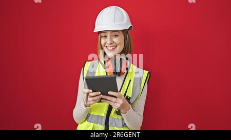 Young blonde woman architect smiling confident using touchpad over isolated red background Stock Photo