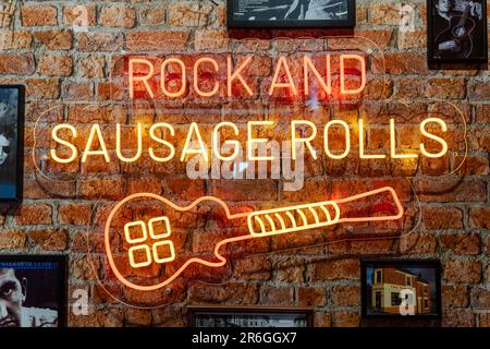 Newcastle upon Tyne, UK. 9th June 2023. Pre-gig, as Sam Fender plays the first of two sold out shows at St James' Park stadium in the city. -- Fenders Unplugged - offering 'Rock and Sausage Rolls' at a live music takeover of the Greggs branch on Grainger Street in the city. Local performers take to the stage in the shop converted to a 'dive bar' as a warm up to the main event this weekend. Credit: Hazel Plater/Alamy Live News Stock Photo