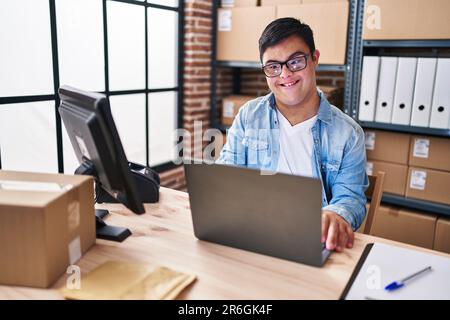 Down syndrome man ecommerce business worker using laptop working at office Stock Photo