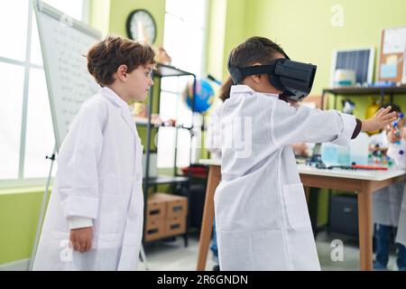 Adorable boys scientist student using virtual reality glasses at laboratory classroom Stock Photo