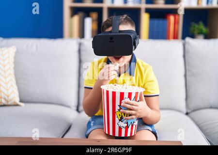 Adorable hispanic boy watching 3d movie sititng on sofa at home Stock Photo
