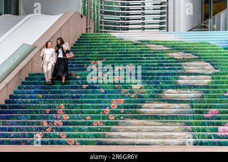 Two Office Workers Walking Down The Colourful Steps Of An Office Building, Hong Kong Island, Hong Kong, China. Stock Photo