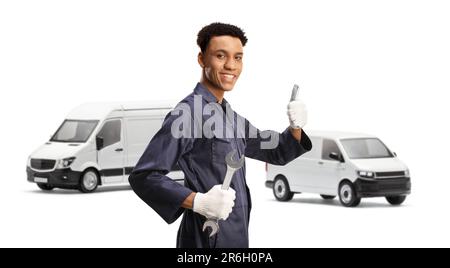 African american mechanic gesturing thumbs up and standing in front of two vans isolated on white background Stock Photo