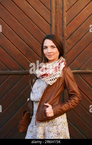 Outdoor fashion portrait of pretty young woman wearing brown leather jacket Stock Photo