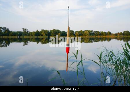 Fishing float in the air over the air. Fishing bobber at the lake in the forest. Stock Photo