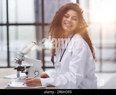 Attractive female scientist looking through a microscope Stock Photo