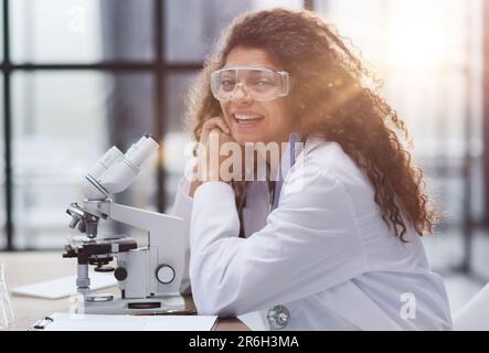 Young woman in biological laboratory. Attractive young female scientis. Scientist using a microscope in a laboratory Stock Photo