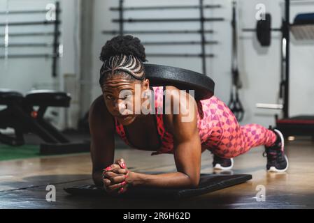 A woman doing push-ups with her personal trainer in a gym Stock Photo