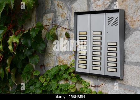 Modern intercom on concrete wall with stone fragments Stock Photo