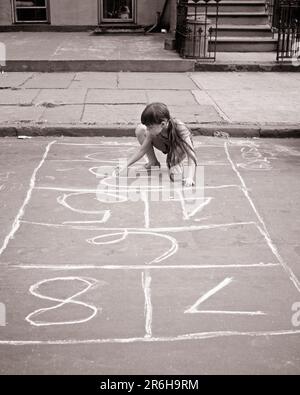 1960s LITTLE URBAN GIRL MARKING HOPSCOTCH GAME SQUARES ON CITY STREET WITH CHALK NYC USA - j13269 HAR001 HARS UNITED STATES COPY SPACE FULL-LENGTH UNITED STATES OF AMERICA DANGER PLANNING RISK CONFIDENCE B&W NORTH AMERICA GOALS NORTH AMERICAN HAPPINESS HIGH ANGLE STRENGTH COURAGE CHOICE EXCITEMENT RECREATION PRIDE ON OPPORTUNITY NYC CONCEPTUAL NEW YORK CITIES ESCAPE STYLISH CURB NEW YORK CITY GROWTH GUTTER HOPSCOTCH JUVENILES PRECISION RELAXATION BLACK AND WHITE CAUCASIAN ETHNICITY HAR001 MARKING OLD FASHIONED SQUARES Stock Photo
