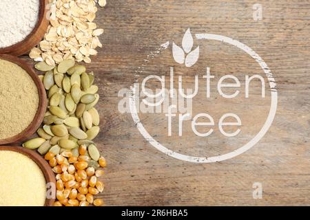 Gluten free products. Bowls with different types of flour and text on wooden table, top view Stock Photo