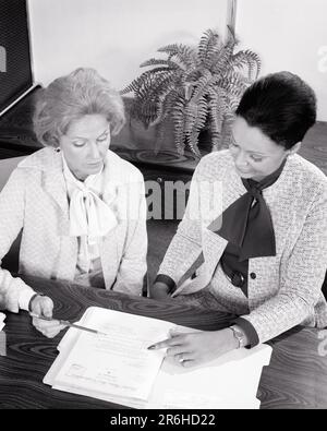 1970s CAUCASIAN AND AFRICAN AMERICAN WOMAN WORKING TOGETHER SIDE BY SIDE REVIEWING INFORMATION IN A FOLDER - o4080 HAR001 HARS OLD FASHION 1 STYLE DIVERSE COMMUNICATION CAREER TEAMWORK INFORMATION LIFESTYLE FEMALES JOBS MANAGER COPY SPACE FRIENDSHIP HALF-LENGTH LADIES PERSONS FOLDER CORPORATE PROFESSION MANAGEMENT EXECUTIVES MIDDLE-AGED B&W SUCCESS SKILL SUIT AND TIE OCCUPATION SKILLS MIDDLE-AGED WOMAN HIGH ANGLE DISCOVERY DISCUSSING LEISURE AFRICAN-AMERICANS AFRICAN-AMERICAN AND CAREERS BLACK ETHNICITY OCCUPATIONS HIGH TECH REVIEWING STYLISH LAST WILL COOPERATION DEEDS MANAGERS MID-ADULT Stock Photo