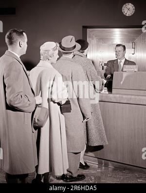 1950s 4 CUSTOMERS TWO MEN TWO WOMEN STANDING IN LINE IN BANK WAITING TO SEE THE SAVINGS ACCOUNTS BANK TELLER MAN BEHIND COUNTER - o916 HAR001 HARS LIFESTYLE FIVE FEMALES 5 JOBS COATS COPY SPACE FULL-LENGTH LADIES PERSONS BANKING MALES DEPOSIT CONFIDENCE BANKER B&W FINANCIAL GOALS SKILL OCCUPATION SKILLS HEAD AND SHOULDERS CUSTOMER SERVICE REAR VIEW OPPORTUNITY OCCUPATIONS WITHDRAWAL CONCEPTUAL FROM BEHIND STYLISH PATIENCE WAIT BACK VIEW COOPERATION MID-ADULT MID-ADULT MAN MID-ADULT WOMAN BLACK AND WHITE CAUCASIAN ETHNICITY HAR001 OLD FASHIONED Stock Photo