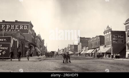 1900s 1910 THREE BOYS STANDING IN CENTER OF COMMERCIAL STREET LOOKING AT CAMERA OTHER MEN WALKING ON SIDEWALK EMPORIA KANSAS USA - q45703 CPC001 HARS ARCHITECTURE TRANSPORT UNITED STATES COPY SPACE FRIENDSHIP FULL-LENGTH PERSONS UNITED STATES OF AMERICA MALES KANSAS BUILDINGS WHEELS TRANSPORTATION B&W NORTH AMERICA NORTH AMERICAN WIDE ANGLE STRUCTURE URBAN CENTER MAMMALS PROPERTY KS PROGRESS TRIO REAL ESTATE STRUCTURES WAGONS EDIFICE EMPORIA GROWTH MAMMAL TOGETHERNESS BLACK AND WHITE GREAT PLAINS MAIN STREET MIDWEST MIDWESTERN OLD FASHIONED Stock Photo