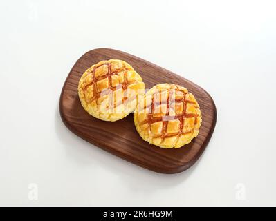 Two delicious desserts served on a small wooden plate, placed on a rustic wooden table Stock Photo