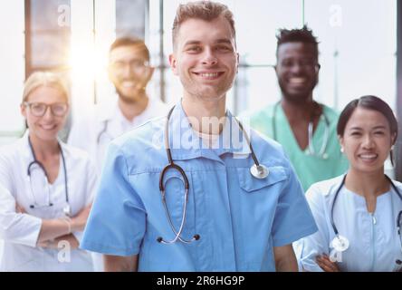 Smiling group of scientists in modern office with male leader, mixed race Stock Photo