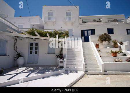 Ios, Greece - May 16, 2021 : A  whitewashed hotel that rents rooms, with the typical Cycladic architecture,  in front of the  Mylopotas Ios Greece Stock Photo