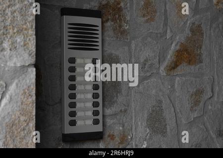 Modern intercom on concrete wall with stone fragments, space for text. Security system Stock Photo