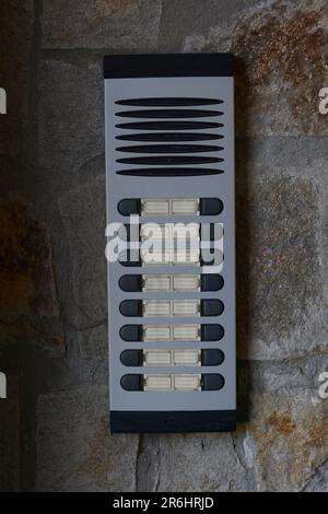 Modern intercom on concrete wall with stone fragments. Security system Stock Photo