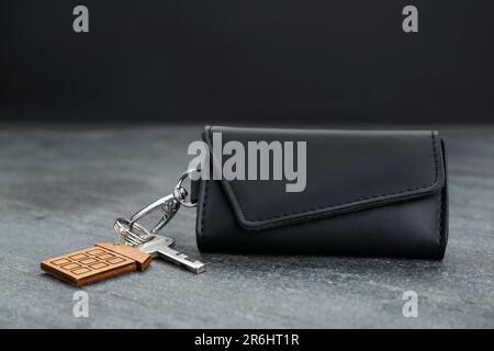 Leather case with key on grey table, closeup Stock Photo