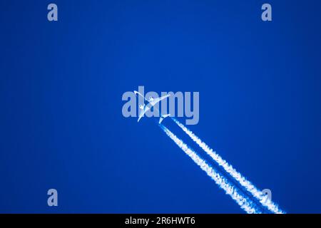 Sharp telephoto close up of jet plane aircraft with contrails cruising