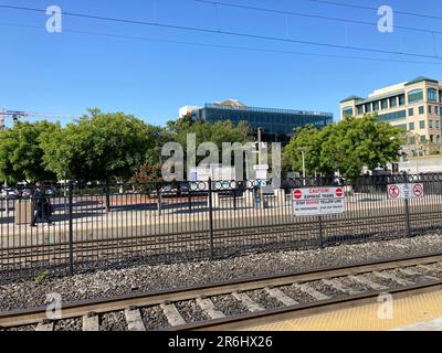 Empty passenger platform of Caltrain station with modern office buildings in background - Sunnyvale, California, USA - 2023 Stock Photo