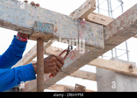 Workers use scaffolding wire to support the floor pouring concrete in construction site.. Stock Photo