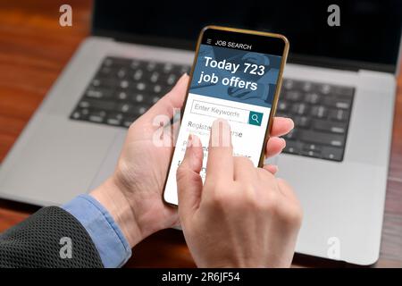 A woman is looking through jobs online using a mobile job search app on her phone. recruitment concept, back view Stock Photo