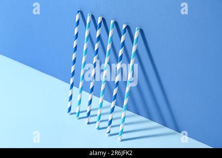 Different paper drinking straws on blue background Stock Photo