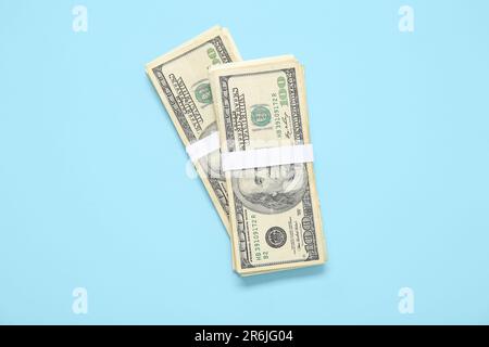 Bundles of one hundred dollar banknotes on blue background Stock Photo